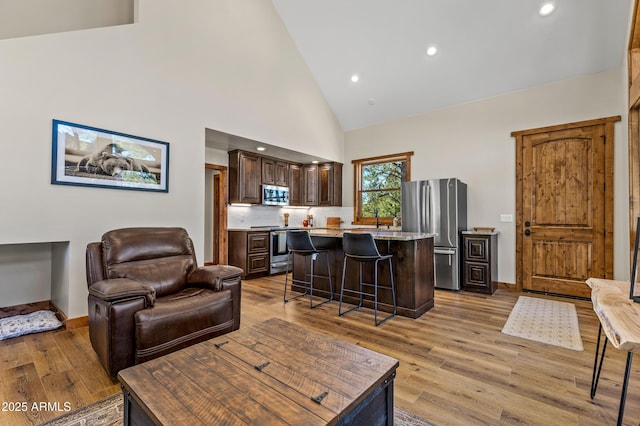 7500 E Old Walnut Canyon Rd, Flagstaff, AZ 86004 - living area with baseboards, high vaulted ceiling, and light wood-type flooring