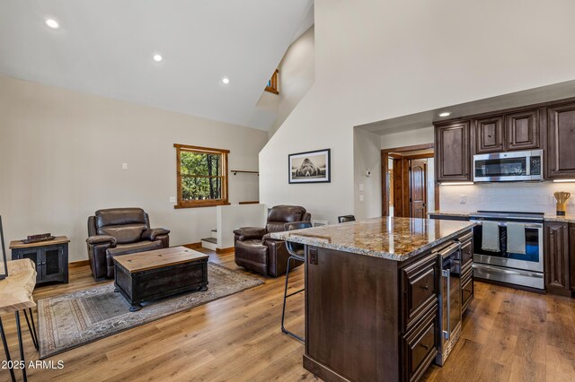 7500 E Old Walnut Canyon Rd, Flagstaff, AZ 86004 - kitchen with a breakfast bar, light wood finished floors, stainless steel appliances, and open floor plan