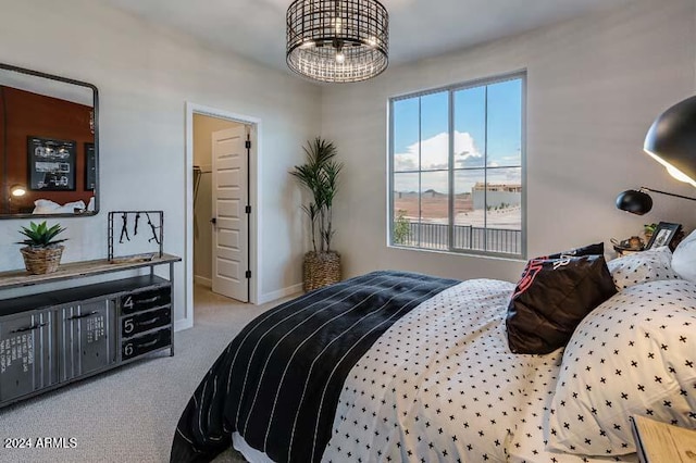 bedroom featuring a spacious closet, a notable chandelier, and carpet floors