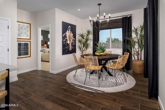 dining area with dark hardwood / wood-style floors and an inviting chandelier