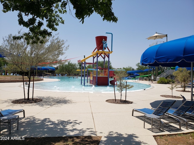 view of swimming pool featuring a playground