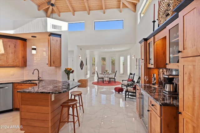 kitchen with stainless steel dishwasher, sink, pendant lighting, wooden ceiling, and dark stone countertops