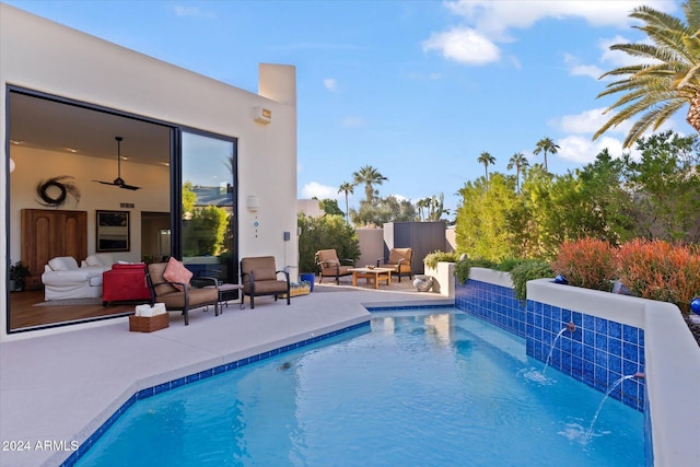 view of pool featuring pool water feature, a patio, and an outdoor hangout area