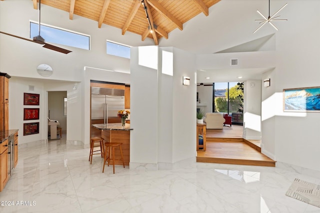 interior space featuring beamed ceiling, wooden ceiling, and high vaulted ceiling