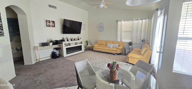 carpeted living room with ceiling fan and vaulted ceiling