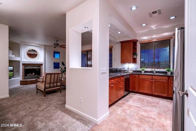 kitchen with sink, appliances with stainless steel finishes, light carpet, and ceiling fan