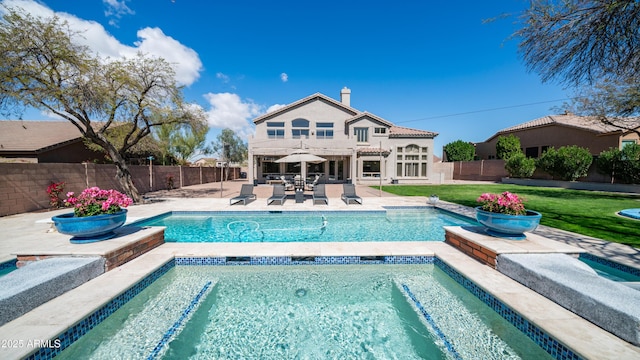 rear view of property with a patio, a yard, a fenced backyard, and a fenced in pool