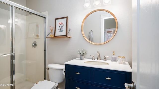 bathroom with toilet, a stall shower, and vanity