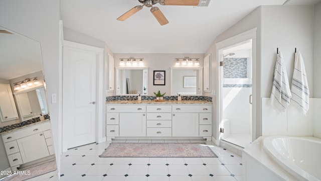 full bathroom with a ceiling fan, double vanity, a sink, a shower stall, and a garden tub