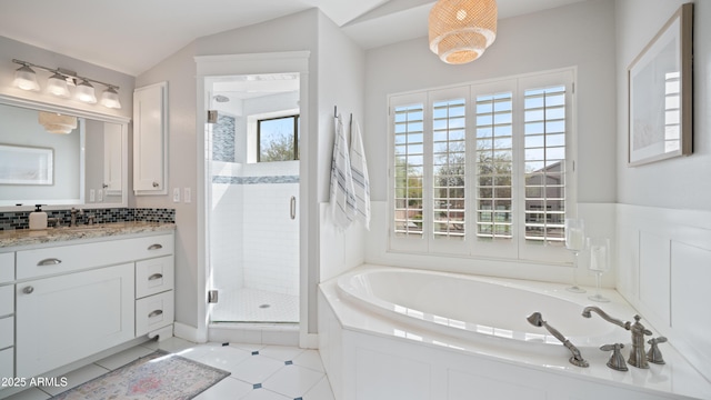 bathroom with tile patterned flooring, a shower stall, lofted ceiling, a garden tub, and vanity