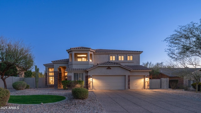 view of front of home with stucco siding, driveway, a tile roof, fence, and a garage