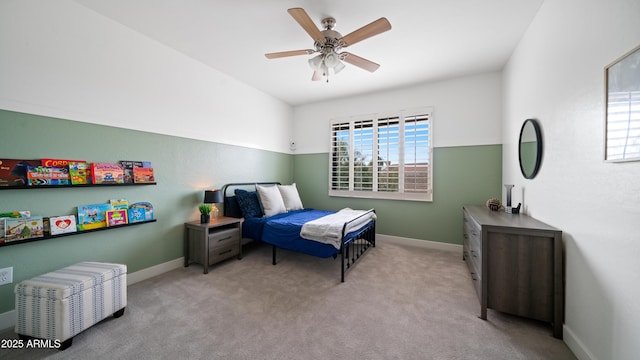 bedroom featuring baseboards, light colored carpet, and ceiling fan