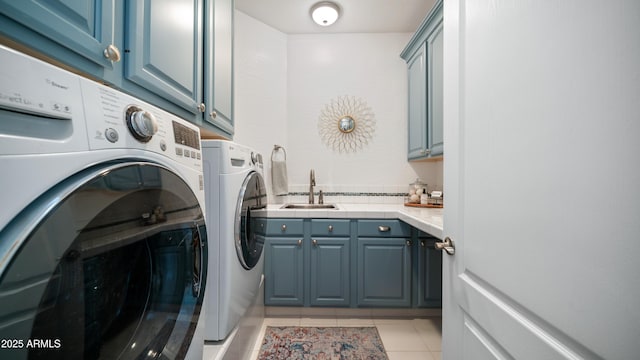 laundry room featuring washer and clothes dryer, cabinet space, light tile patterned flooring, and a sink