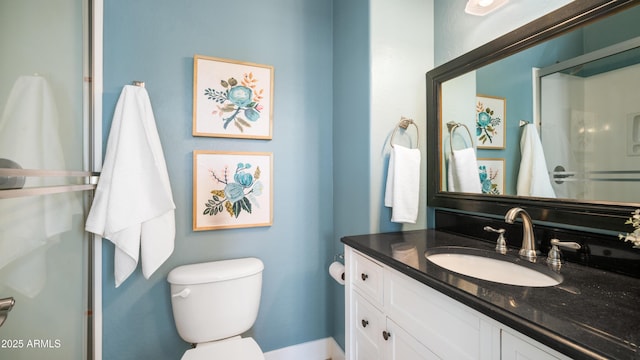 bathroom with vanity, toilet, and a shower stall