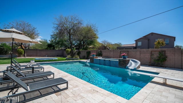 view of pool featuring a fenced in pool, an in ground hot tub, a fenced backyard, and a patio area