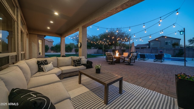 view of patio / terrace with a fenced in pool, an outdoor living space with a fire pit, and a fenced backyard