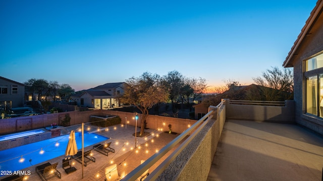 pool at dusk with a fenced in pool, a fenced backyard, and a patio area