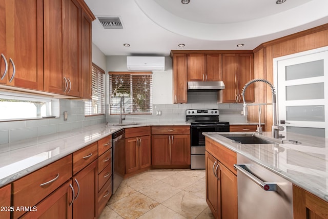 kitchen with appliances with stainless steel finishes, a wall mounted AC, light stone countertops, and sink