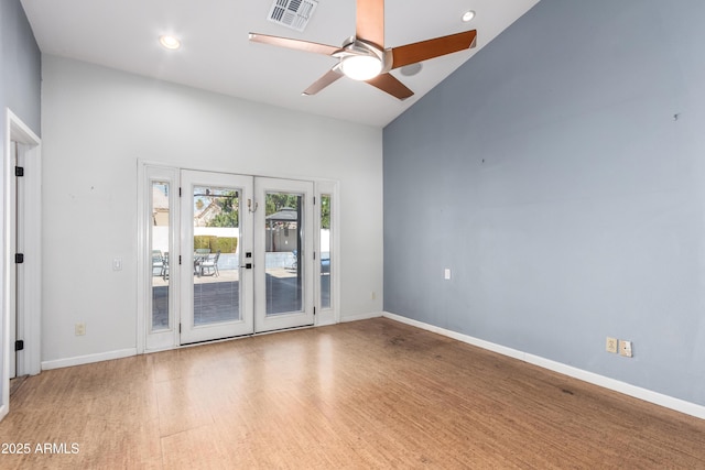 unfurnished room with french doors, hardwood / wood-style floors, high vaulted ceiling, and ceiling fan