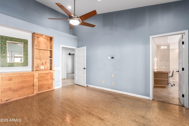 unfurnished bedroom with ceiling fan, connected bathroom, and high vaulted ceiling