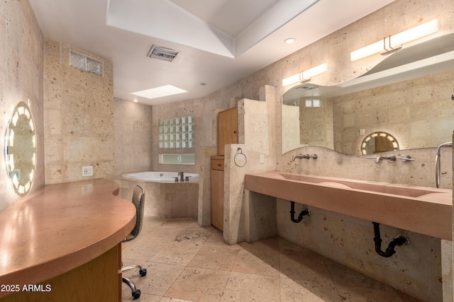 bathroom featuring tile walls, sink, and tiled bath