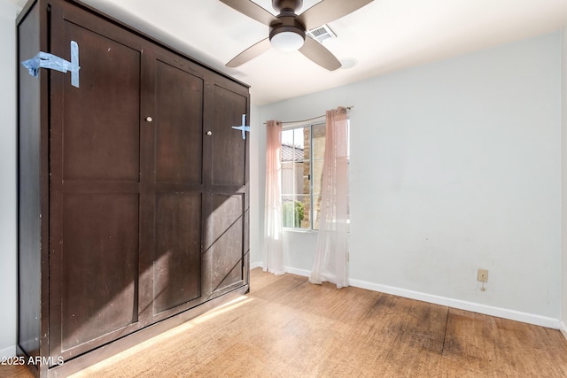 empty room with ceiling fan and light wood-type flooring