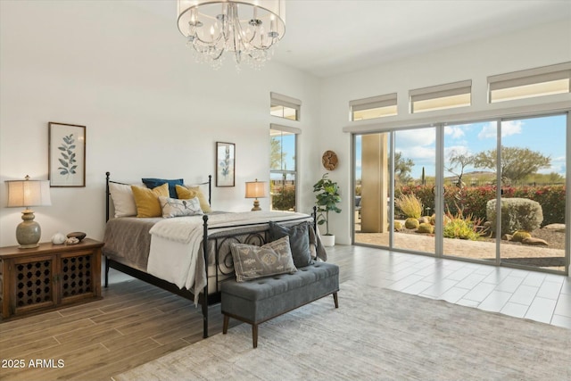 17413 E Hidden Green Ct, Rio Verde, AZ 85263 - bedroom featuring access to outside, wood finish floors, and a notable chandelier
