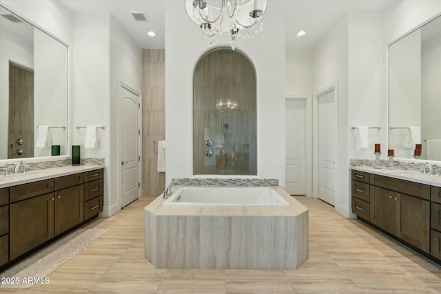17413 E Hidden Green Ct, Rio Verde, AZ 85263 - full bathroom featuring a notable chandelier, a tile shower, two vanities, a bath, and visible vents