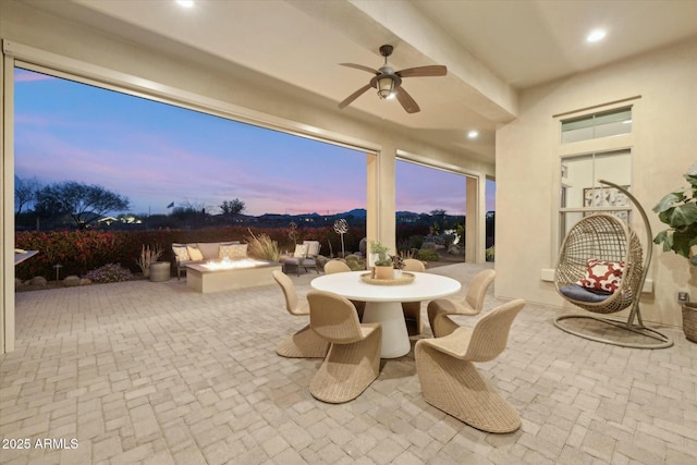 17413 E Hidden Green Ct, Rio Verde, AZ 85263 - patio terrace at dusk featuring an outdoor fire pit, outdoor dining space, and a ceiling fan