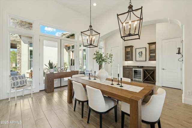 17413 E Hidden Green Ct, Rio Verde, AZ 85263 - dining area featuring light wood-style floors, vaulted ceiling, wine cooler, and a chandelier