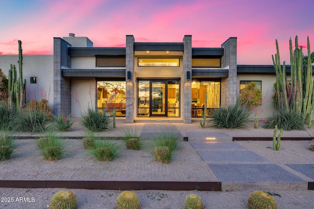 rear view of property featuring stucco siding