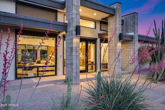 doorway to property featuring stucco siding