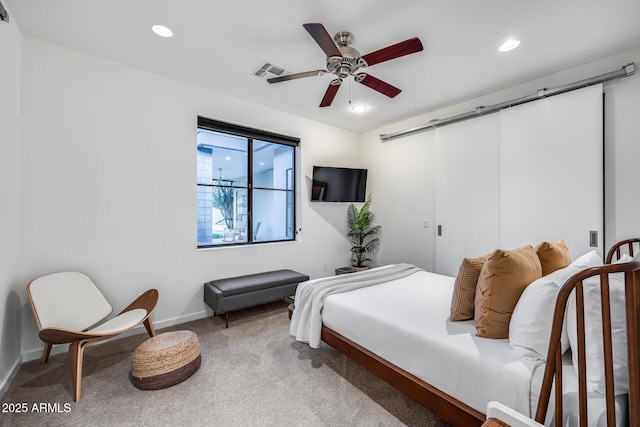 carpeted bedroom featuring ceiling fan, a barn door, recessed lighting, baseboards, and visible vents