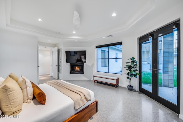 bedroom with visible vents, access to exterior, recessed lighting, a tray ceiling, and a lit fireplace