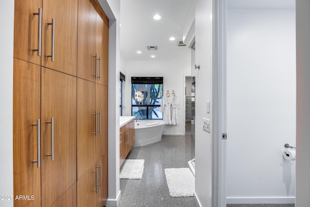 full bathroom featuring visible vents, vanity, a freestanding tub, baseboards, and recessed lighting