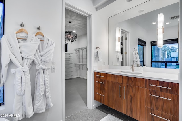 bathroom featuring a notable chandelier, baseboards, visible vents, and vanity