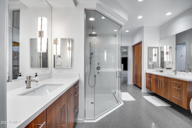 full bath featuring recessed lighting, a sink, a stall shower, and two vanities