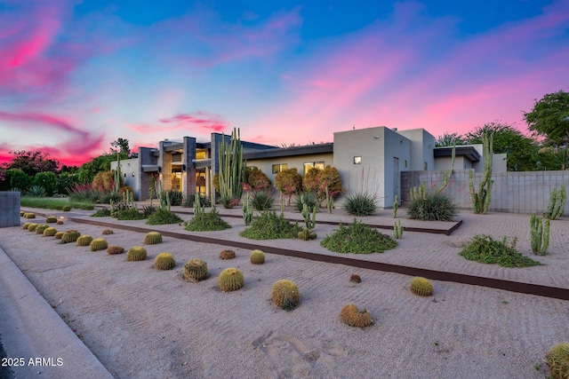 modern home with fence and stucco siding