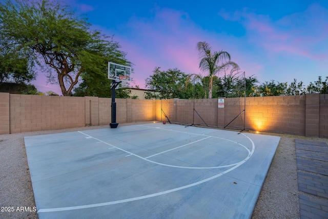 view of basketball court with basketball hoop and a fenced backyard