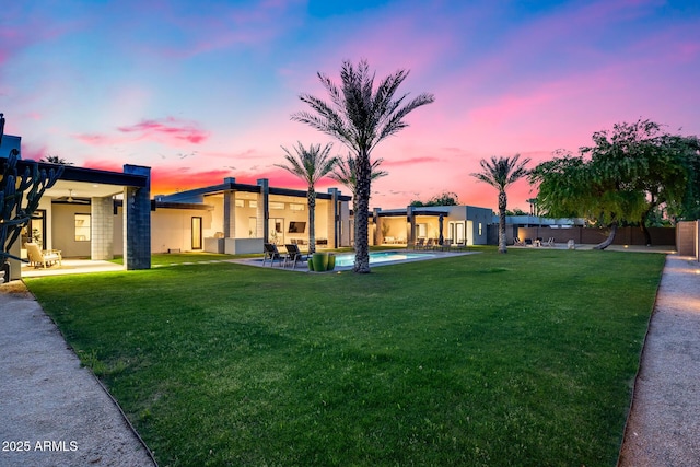 view of front facade with a front yard, a patio area, and stucco siding