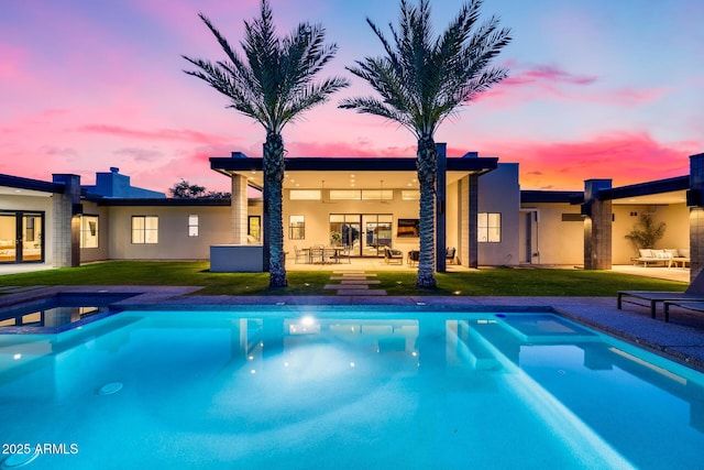view of swimming pool featuring a lawn, a patio, and a pool with connected hot tub