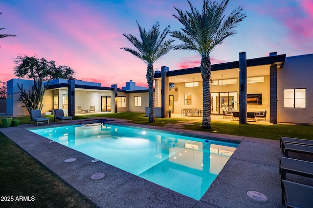 outdoor pool with a lawn, a patio area, and an outdoor hangout area