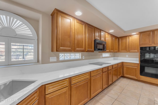 kitchen with brown cabinetry, black appliances, recessed lighting, and light tile patterned flooring