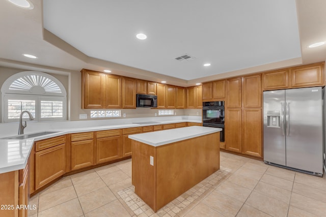 kitchen with a sink, black appliances, light tile patterned flooring, and visible vents