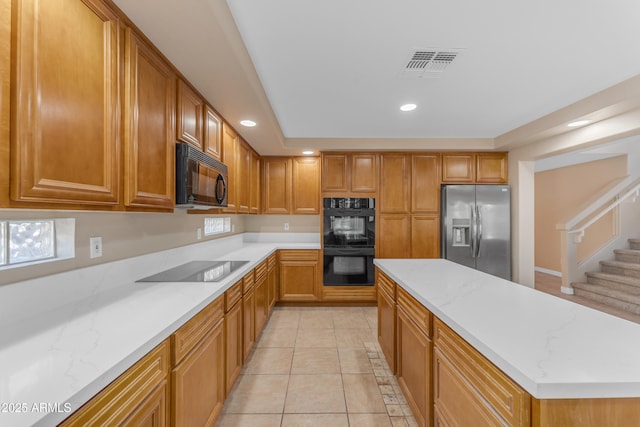 kitchen with recessed lighting, visible vents, light stone counters, and black appliances