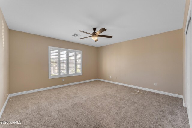 empty room with visible vents, a ceiling fan, carpet, and baseboards