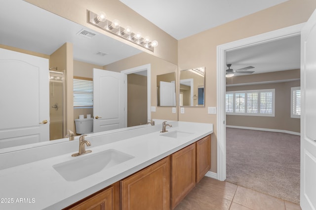 full bath with a sink, a ceiling fan, a stall shower, and visible vents