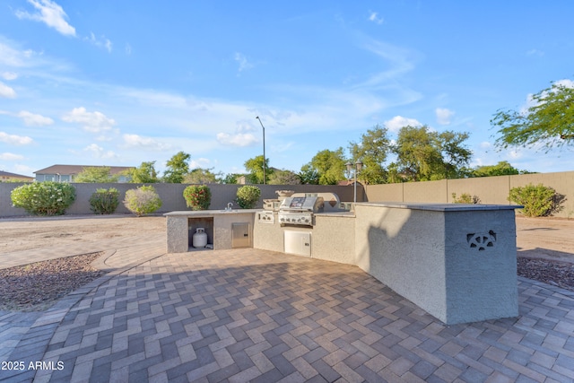 view of patio with grilling area, exterior kitchen, and a fenced backyard