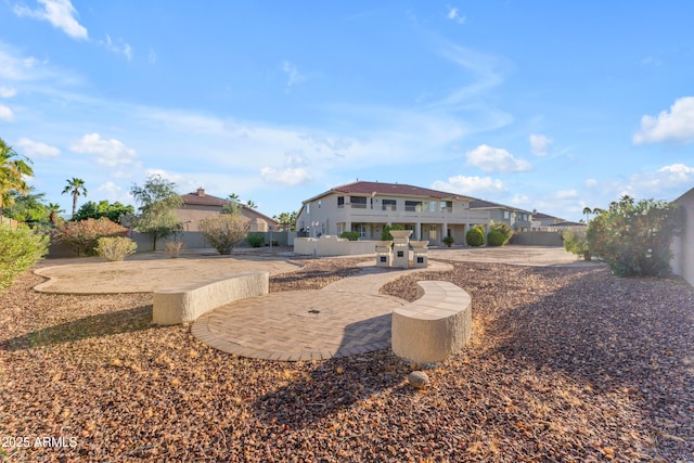 rear view of property with a fenced backyard and a patio