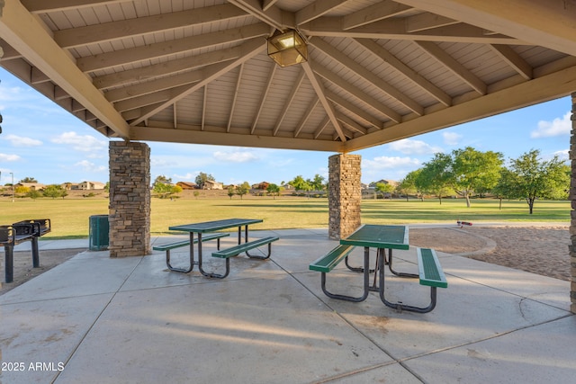 view of property's community featuring a lawn and a patio area